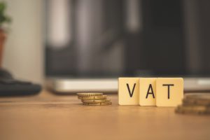 VAT concept. Word VAT and coins business desktop background with laptop. Business and investment VAT concept. Word VAT and coins business desktop background with laptop. Business and investment photo